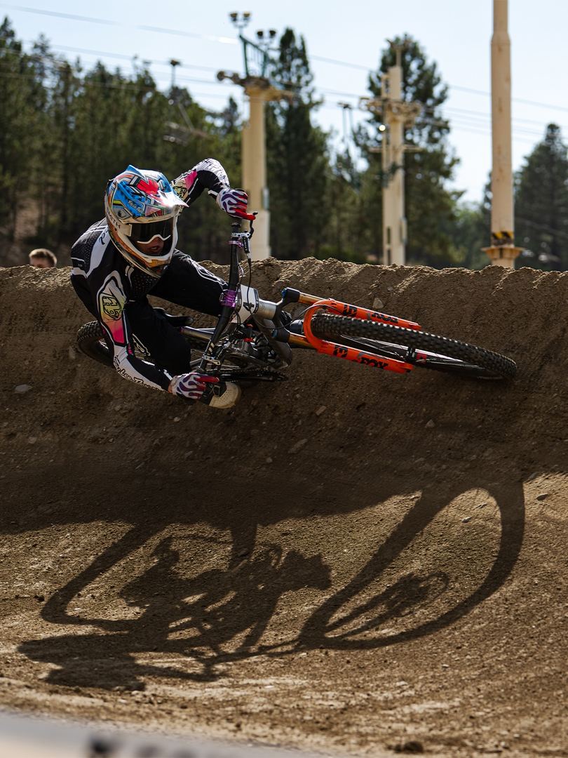 Fred railing a dirt berm with his shadow stretched across the turn
