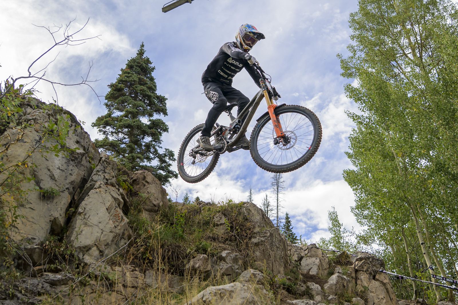 Fred jumping off a rock against a big sky